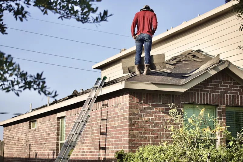 Professional roofer working on a residential roof in Winsted